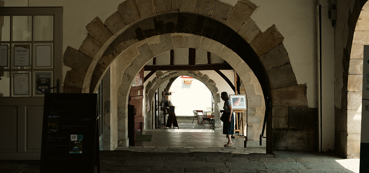 Bastide Clairence, Bogengang, Frau | © Bert Schwarz 2025