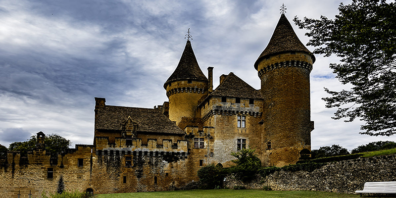 Chateau de Puymartin hinter Bäumen und Mauern; Schauplatz der Legende der Weissen Dame und historischer Tatort. | © Bert Schwarz 2021